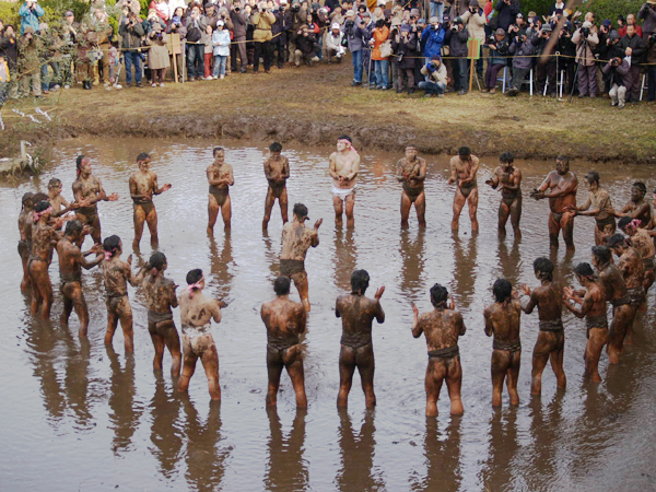 Halfnaked men gathered in cold muddy water to entertain the Gods